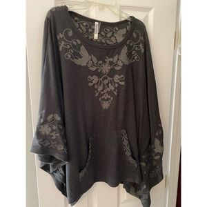 Grey poncho with floral details, worn maybe once